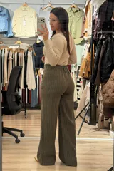 Pantalon sastrero de corte recto y tiro alto, color marrón con diseño de rayas verticales finas. Cuenta con cierre frontal con botón y bolsillos laterales.