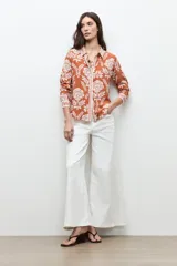 Camisa de manga larga con estampado floral en tonos ladrillo y blanco, con cuello camisero y cierre frontal de botones.