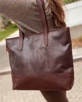 Bolso tipo tote de cuero vacuno color chocolate, con textura efecto cocodrilo en la parte superior y base lisa. Cuenta con doble asa de hombro y cierre superior.