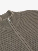 Chaqueta de punto de algodón color marrón, con cuello alto y cierre frontal con cremallera.