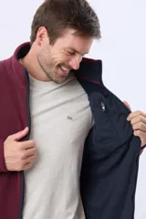 Campera polar térmica de corte recto y cuello alto, con cierre frontal completo en contraste. Presenta bolsillos laterales con cierre y un bolsillo vertical en el pecho, todos con detalles en color azul marino.