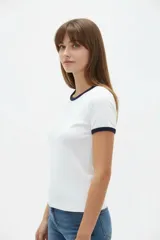 Remera de viscosa blanca con detalles en azul marino en el cuello redondo y los puños de las mangas cortas, de corte ajustado al cuerpo.