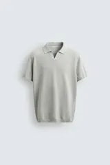 Jersey de punto color gris claro, manga corta, con cuello solapa y abertura frontal en V. Corte relajado.