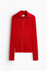 Top de manga larga confeccionado en tejido de punto acanalado. Presenta un diseño de ajuste ceñido con cuello alto y cierre frontal parcial.