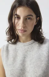 Chaleco de punto sin mangas, color gris, con cuello redondo y corte holgado. Confeccionado con hilo italiano de textura mullida y compacta.