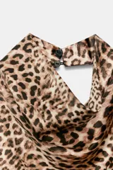Top halter satinado con estampado de leopardo, cuello desbocado y espalda descubierta con cierre de botón en la nuca.
