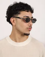 Lentes de sol ovalados con montura plateada y lentes oscuros.