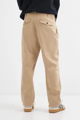 Pantalón recto color beige, confeccionado en mezcla de algodón y elastano, con cierre de botón y bolsillos laterales.