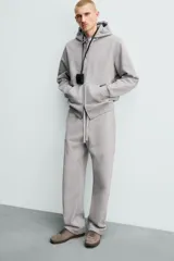 Pantalón jogger de corte regular fit y color negro, confeccionado en tejido compacto de algodón con interior de rizo. Cuenta con cintura elástica, bolsillos frontales y un bolsillo trasero de doble vivo.