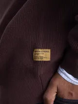Sweater de cuello redondo confeccionado en algodón grueso con textura acanalada, de corte clásico y manga larga.