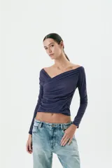 Top azul marino de manga larga con escote asimétrico y frunces laterales.