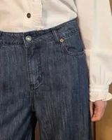Pantalón de jean estilo wide leg, color azul oscuro, con diseño de pierna ancha y ruedo desflecado.