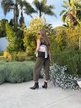 Mochila urbana de diseño combinado, confeccionada en tela resistente con bolsillo frontal y detalles en cuero sintético. Cuenta con compartimento principal con cierre y correas ajustables.