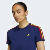 Remera de algodón azul marino de corte clásico y cuello redondo. Presenta las tres franjas características de Adidas en los hombros y mangas en colores rojo, amarillo y marrón. El logo del trébol de Adidas se encuentra bordado en color dorado en el pecho.