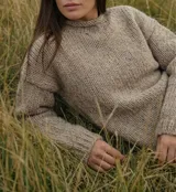 Sweater de tejido de punto grueso, color visón, con cuello redondo y diseño oversize de calce holgado.