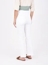 Pantalón de jean blanco, de corte recto y tiro alto, con terminación desflecada en el ruedo.