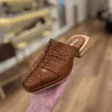 Zueco de cuero color marrón con diseño fruncido en la parte delantera y taco bajo.