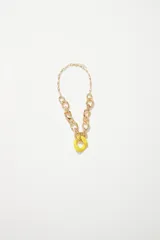 Collar dorado de cadenas con eslabones grandes y pequeños, con dije colgante en forma de aro de resina color amarillo.