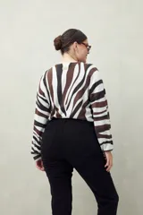 Pantalón chupín negro de tiro alto, confeccionado en denim suave y levemente elástico, con bolsillos delanteros y traseros.