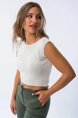 Musculosa blanca de tejido de punto calado, con cuello redondo y sisas anchas.