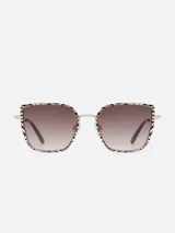 Lentes de sol Carolina Lemke con montura metálica dorada y diseño geométrico con estampado animal print. Lentes color marrón degradado.