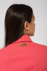 Camisa oversize color fucsia, de lino, con cuello camisero, cierre frontal con botones y mangas largas abullonadas con puños elásticos.