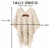 Ruana confeccionada en lana merino color beige, de diseño amplio y envolvente con flecos en el borde inferior y un broche artesanal de cuero en el frente.