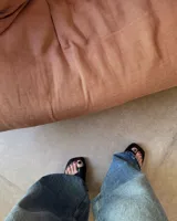 Sandalias negras de cuero vacuno con tira ancha sobre el empeine y espacio para el dedo gordo.