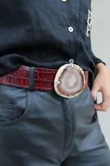 Cinto de cuero azul con hebilla circular de piedra ágata con borde dorado.