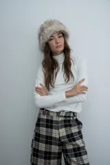 Polera de manga larga en color negro, con cuello alto y costuras decorativas visibles en el frente que realzan la silueta.