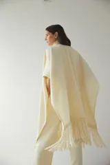 Ruana marrón con flecos y bolsillos. Terminaciones envivadas.