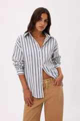 Camisa de manga larga con diseño de rayas verticales en tonos azul, blanco y beige, cuello camisero y cierre frontal de botones.