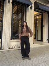 Pantalon baggy de bengalina elastizada, color negro, con corte holgado y tiro ajustable. Presenta cierre frontal con boton y bolsillos laterales.
