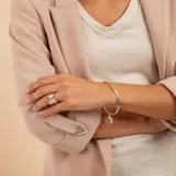 Brazalete tipo esclava de alambre redondo en plata 925, con dije de medalla circular colgante.