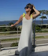 Vestido largo gris con breteles finos y volados en el ruedo. Breteles con lazos de color amarillo neón.