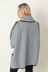 Chaquetón italiano rayado en tonos de natural y negro con vivos en negro. Modelo cruzado que se prende con un botón, amplios bolsillos delanteros y calce holgado.