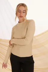 Buzo de tejido de punto color beige con lurex plateado, de cuello alto y mangas largas.