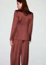 Blazer de corte recto y diseño estructurado, confeccionado en tejido satinado color marrón. Presenta cuello con solapas de muesca, cierre frontal de doble botonadura, bolsillos de solapa en el frente y bolsillo de parche en el pecho. Incluye forro interior y mangas largas con puños abotonados.