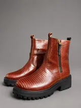 Bota corta de cuero con textura tipo crocco en color chocolate, con suela track negra de goma y cierre lateral.