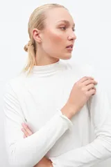 Remera blanca de media polera con mangas largas y volados en los puños.