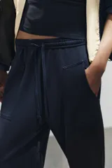 Pantalón de algodón negro con tiro medio, cintura elástica, pierna recta y grandes bolsillos laterales aplicados.