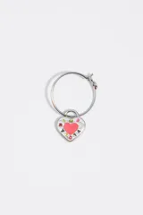 Aros de metal tipo argolla con dije colgante en forma de corazón esmaltado en color blanco y rosado, con detalles de letras estampadas.