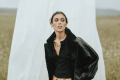 Campera oversize de cuero tostado con solapas y forro interno de corderito sintético azul marino, mangas anchas y detalles de costuras trenzadas.