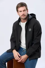 Campera repelente al agua y cortaviento de color negro, con capucha desmontable, cierre frontal y parche circular en el pecho.