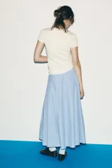 Falda midi celeste con rayas verticales finas en azul marino, de tiro alto, con pliegues en el delantero y cierre lateral con cremallera oculta.