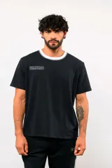 Remera de manga corta Umbro color blanco, con cuello redondo en tono azul oscuro y el logo de la marca bordado en el pecho.