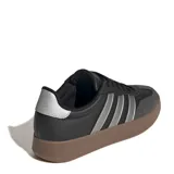 Championes urbanos Adidas modelo Barreda T, color negro con detalles en gris metalizado y suela de goma color marrón. Presentan el diseño clásico de las tres tiras laterales y refuerzos en la puntera.