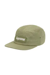 Gorra tipo camp cap de Supreme en color verde oliva, con diseño de patrón hexagonal y logo de la marca bordado en un parche frontal rectangular.