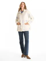 Chaqueta de corte relajado confeccionada en tejido tipo corderito color crema, combinada con paneles de matelassé en el frente y bolsillos. Presenta un delicado bordado floral en tonos azules sobre el corderito, cierre frontal metálico dorado y bolsillos de parche delanteros.