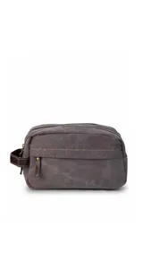 Neceser de tela canvas color gris, con diseño de doble compartimento con cierre, bolsillo frontal con cierre y asa lateral de cuero sintético.